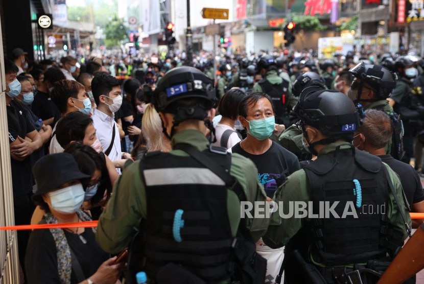 Petugas polisi menghentikan pengunjuk rasa di belakang penjagaan selama unjuk rasa yang dilarang pada Hari Nasional China di Hong Kong, China, 01 Oktober 2020. 