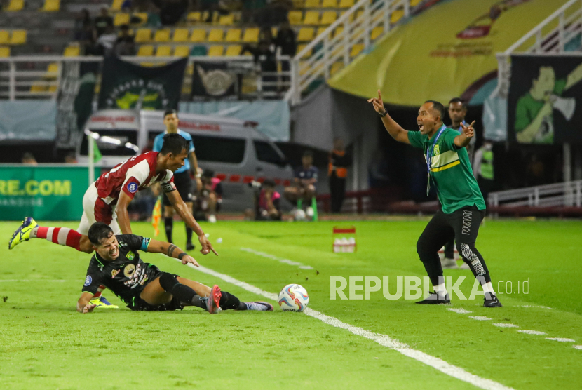 Pesepak bola Persebaya Surabaya Bruno Moreira Soares (tengah) terjatuh saat dihadang pesepak bola Persis Solo Eky Taufik Febrianto (kiri) pada pertandingan BRI Liga 1 di Stadion Gelora Bung Tomo, Surabaya, Jawa Timur, Rabu (13/12/2023). Pertandingan berakhir imbang 1-1. 