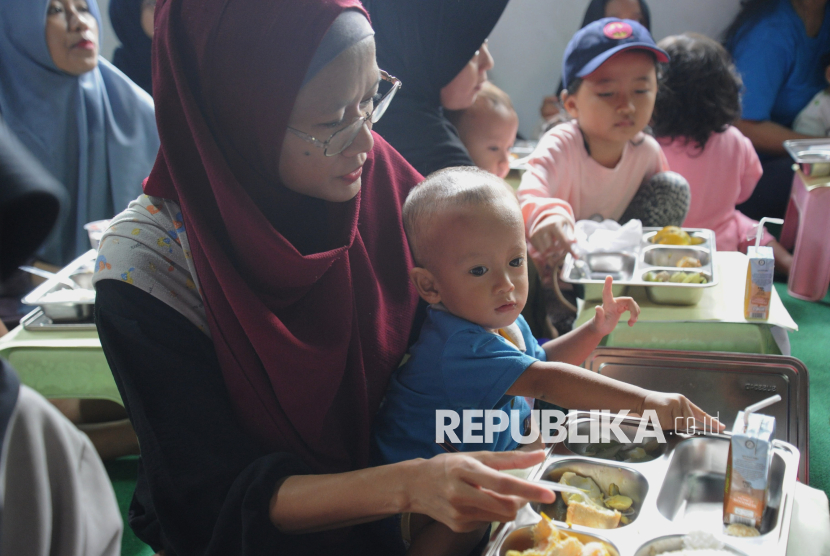Sejumlah orangtua mendampingi anak balitanya menyantap hidangan makan bergizi gratis (MBG) untuk balita, ibu hamil, dan ibu menyusui di Posyandu Dahlia, Ciracas, Jakarta, Jumat (10/1/2025). Pemerintah memulai program makan bergizi gratis untuk ibu hamil, ibu menyusui, hingga anak balita.  Progam MBG untuk balita, ibu hamil, dan ibu menyusui tersebut merupakan kelanjutan dari program MBG untuk pelajar yang telah dilaksanakan sejak Senin (6/1/2025) lalu. Adapun menu makanan untuk balita di lokasi tersebut hari ini yaitu nasi putih, telur, sayur labu, buah jeruk, dan susu. Program pemberian makan bergizi gratis ini diberikan untuk pemenuhan gizi ibu hamil, balita dan ibu menyusui terjaga. Selain itu juga mencegah stunting.