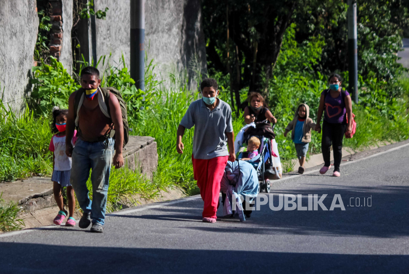  Migran Venezuela berjalan di jalan raya yang sarat dengan koper dan tas di San Cristobal