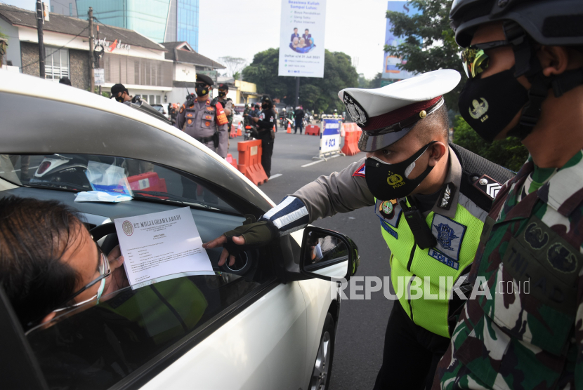 Pengendara menunjukkan Surat Tanda Registrasi Pekerja (STRP) kepada petugas di pos penyekatan pembatasan mobilitas masyarakat pada PPKM Darurat 