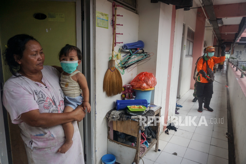 Petugas Dinas Lingkungan Hidup (DLH) Solo menyemprotkan cairan disinfektan di Rusunawa Semanggi, Solo, Jawa Tengah, Rabu (18/3/2020). Penyemprotan tersebut dilakukan untuk antisipasi penyebaran COVID-19 di kawasan permukiman padat penduduk. (Antara/Mohammad Ayudha)