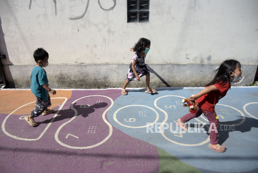 Sejumlah anak bermain di jalan yang telah dilukis mural di Gang Sayuran 2, Gempolsari, Kota Bandung, Kamis (2/12/2021). Orang tua harus tetap bersabar dan tidak berhenti menanamkan sikap empati pada anaknya.