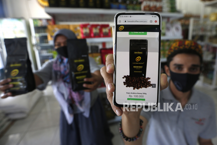 Pelaku usaha mikro kecil menengah (UMKM) menunjukan aplikasi pemasaran produk kopi arabika dan robusta gayo yang dijual secara daring (online) di Banda Aceh, Aceh, Ahad (9/8/2020). Selain memasarkan produk dengan cara tatap muka, para pelaku UMKM juga menjual berbagai hasil usaha dengan cara online sebagai salah satu upaya mencegah penularan COVID-19. 