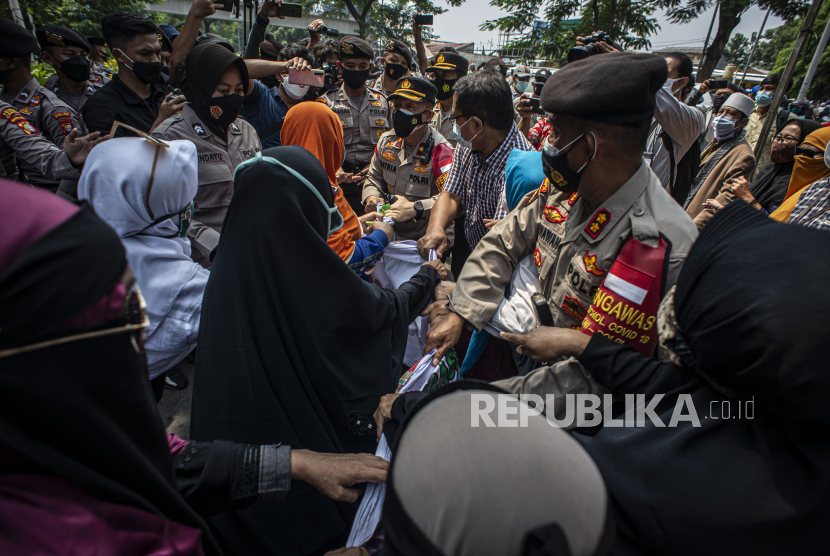 Petugas Kepolisian membubarkan massa pendukung saat berlangsungnya sidang lanjutan kasus pelanggaran protokol kesehatan dengan terdakwa Rizieq Shihab di Pengadilan Negeri (PN) Jakarta Timur, Jakarta, Jumat (19/3/2021). Sidang tersebut beragendakan pembacaan dakwaan dari Jaksa Penuntut Umum (JPU). 