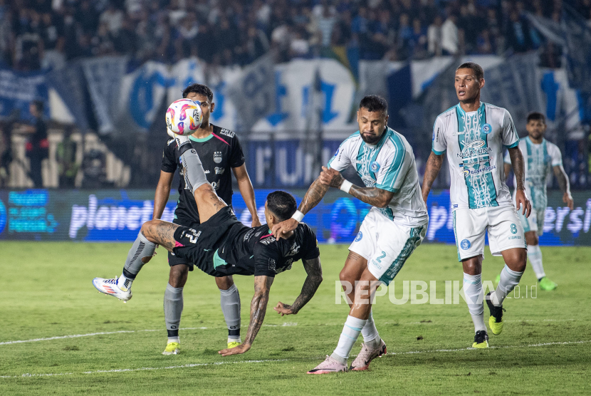 Pesepak bola Persib Bandung Ciro Henrique Alves (kedua kiri) melakukan tendangan dibayangi pesepak bola PSBS Biak Julian Velazquez (kedua kanan) dan Jonata Machado (kanan) saat pertandingan BRI Liga 1 2024/2025 di Stadion Si Jalak Harupat, Kabupaten Bandung, Jawa Barat, Jumat (9/8/2024). Persib Bandung menang atas PSBS Biak dengan skor 4-1. 