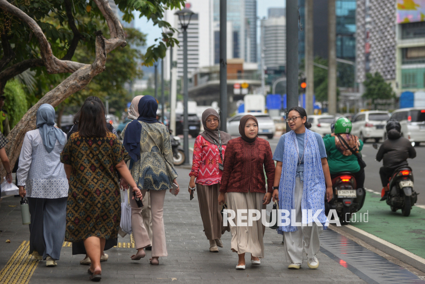 Sejumlah karyawan perkantoranberjalan di kawasan pedestrian Bundaran HI, Jakarta. Pemerintah mengandalkan stimulus fiskal dan percepatan belanja APBN untuk menjaga pertumbuhan ekonomi 2025–2026 di tengah tekanan ekonomi global dan kebijakan tarif Trump 2.0.  (ilustrasi)