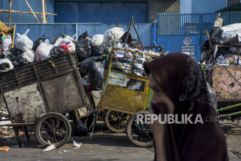 Warga melintas di dekat tumpukan sampah (ilustrasi). Kepala Dinas Lingkungan Hidup Kabupaten Aceh Selatan menyatakan produk sampah harian masyarakat di sana meningkat hingga 20 persen pada Ramadhan 2023.