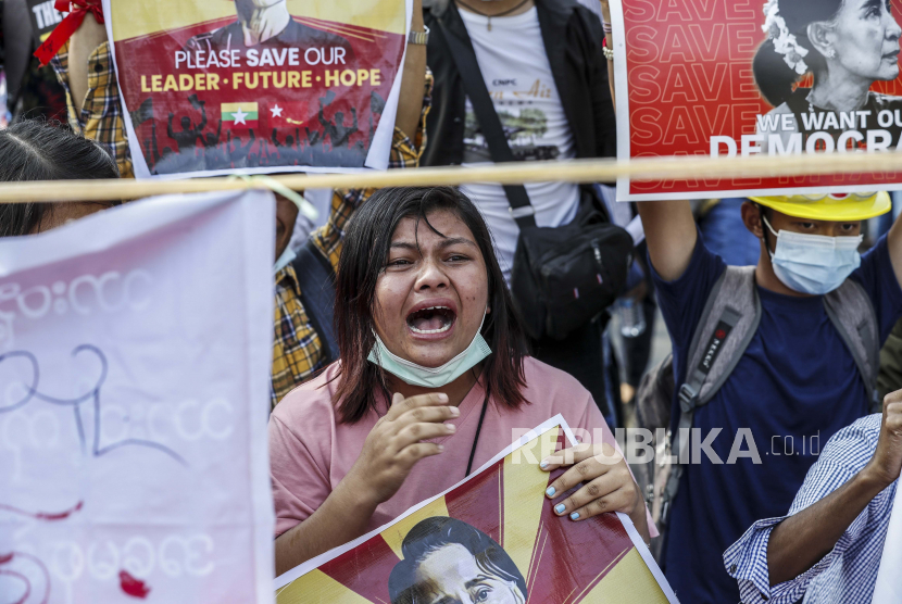 Para pengunjuk rasa mengangkat plakat di depan Bank Sentral selama protes terhadap kudeta militer di Yangon, Myanmar, 16 Februari 2021. Junta militer Myanmar pada 16 Februari menghentikan layanan internet untuk hari kedua berturut-turut karena protes terus berlanjut meskipun pasukan dan lapis baja dikerahkan kendaraan di kota-kota besar.