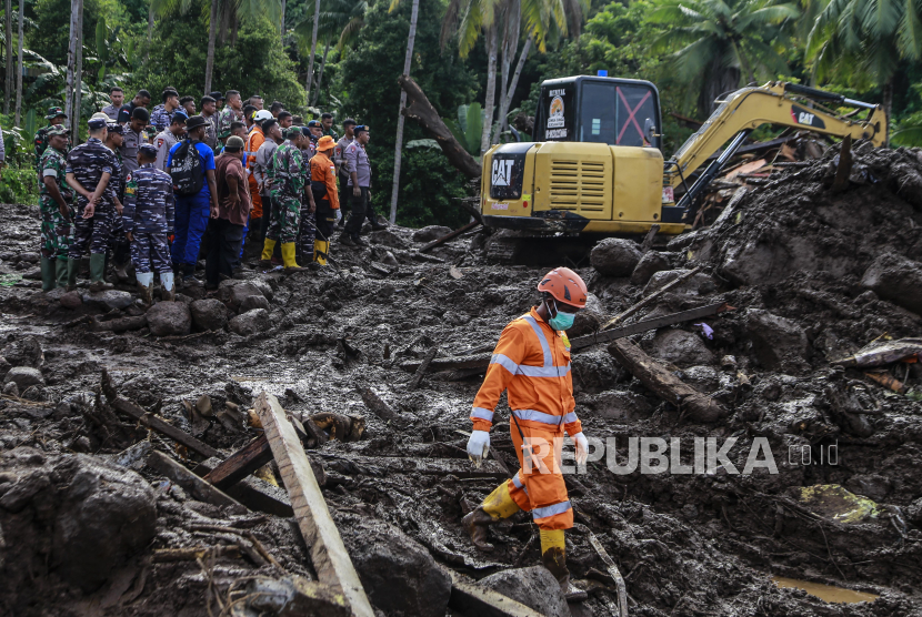 Tim SAR gabungan menyaksikan ekskavator  menyingkirkan material lumpur saat mencarian korban banjir bandang di Kelurahan Rua, Kota Ternate, Maluku Utara, Senin (26/8/2024). 