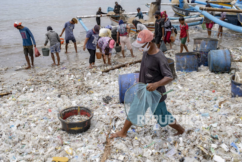 Nelayan bekerja di pantai yang tertutup sampah plastik, di sebuah desa nelayan  (ilustrasi)