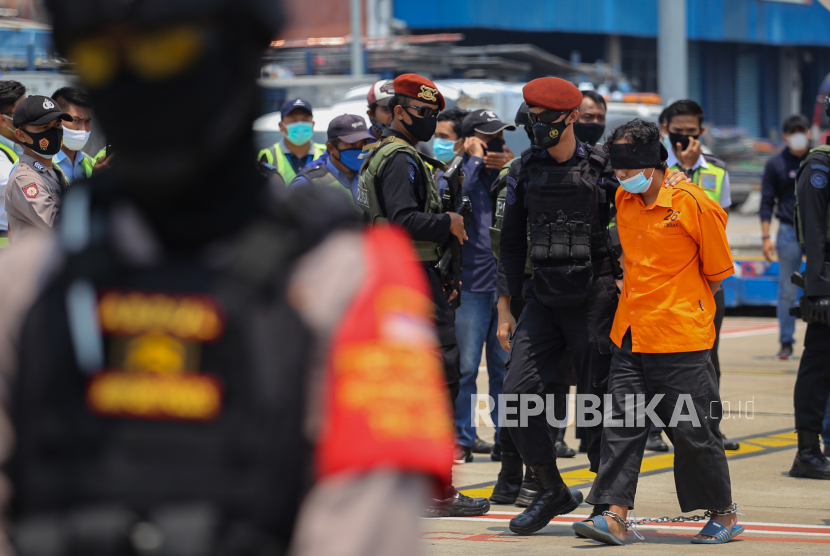 Personel Densus 88 Antiteror Poliri membawa terduga teroris menuju mobil tahanan setibanya di Bandara Internasional Soekarno Hatta, Kota Tangerang, Banten, Kamis (18/3/2021). 