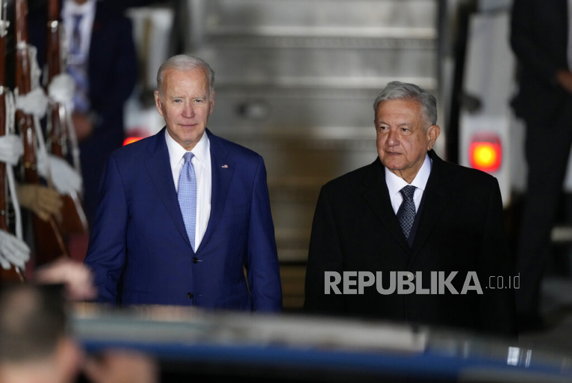  Presiden AS Joe Biden berjalan bersama Presiden Meksiko Andres Manuel Lopez Obrador, saat kedatangannya di bandara internasional Felipe Angeles di Zumpango, Meksiko, Ahad, 8 Januari 2023.