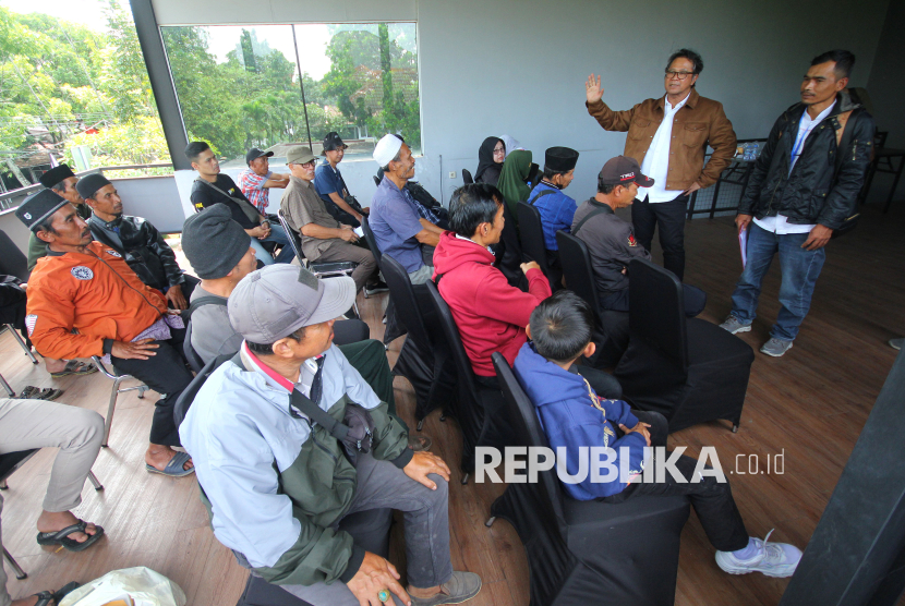 Kuasa hukum warga, Roedi Wiranata Kusumah berupaya menenangkan warga saat aksi puluhan warga terdampak PLTA Upper Cisokan di PLN Unit Induk Pembangunan Jawa Bagian Tenga, Jalan Karawitan, Kota Bandung, Senin (12/2/2025). Mereka mengadukan nasib tanah mereka seluas 10 hektare yang terdampak PLTA Upper Cisokan.