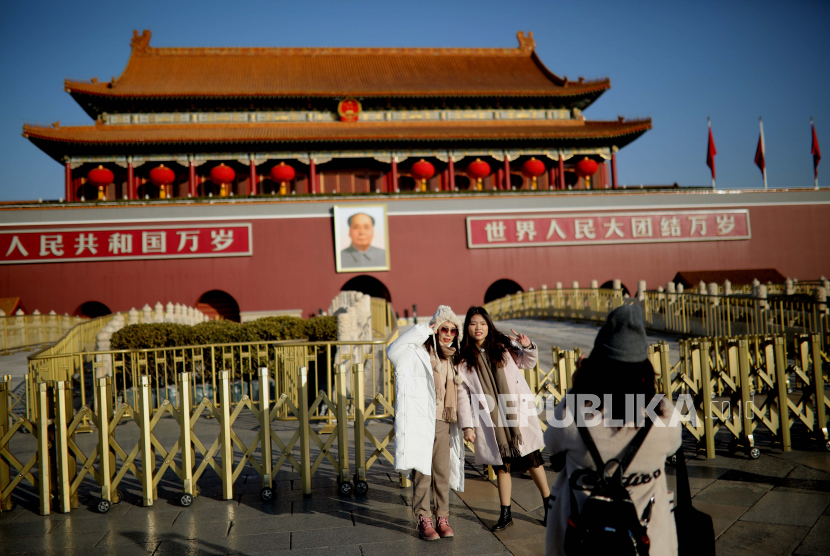 Orang-orang berpose untuk berfoto saat mengunjungi Lapangan Tiananmen selama liburan Tahun Baru 2021, di Beijing, Cina, 01 Januari 2021.