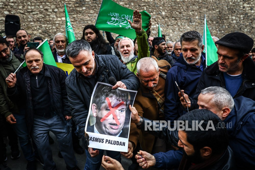 Para pengunjuk rasa mencoba membakar foto politikus sayap kanan Swedia-Denmark Rasmus Paludan di depan Konsulat Jenderal Swedia selama protes di Istanbul, Turki, 22 Januari 2023. Politikus sayap kanan Swedia-Denmark Rasmus Paludan diizinkan menggelar demonstrasi dan membakar mushaf Alquran di depan kedutaan Turki di Stockholm pada 21 Januari 2023.