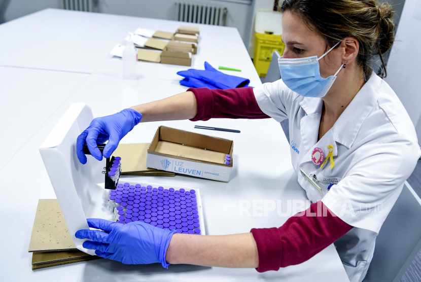 Seorang petugas kesehatan memeriksa botol vaksin Pfizer-BioNTech Covid-19 saat dicairkan di laboratorium di rumah sakit UZ Leuven di Leuven, Belgia, Minggu, 27 Desember 2020. Belgia tak wacanakan lockdown meski kasus Covid-19 kembali melonjak.
