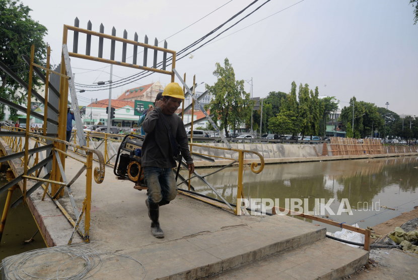 Pekerja membawa genset untuk menyelesaikan pembangunan turap Anak Kali Ciliwung di kawasan Pasar Baru, Jakarta Pusat (ilustrasi)
