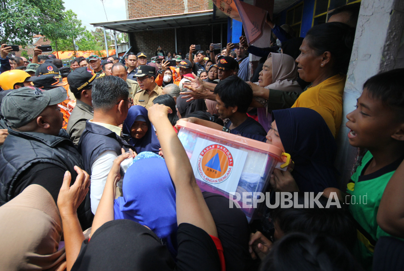 Warga terdampak banjir menerima bantuan saat kunjungan Kepala BNPB Letjen TNI Suharyanto dan Bupati Bandung Dadang Supriatna di Pos Pengungsian Desa Citeureup, Kecamatan Dayeuhkolot, Senin (15/1/2024)