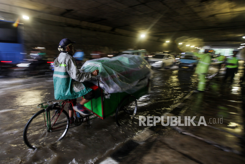 Pedagang kerupuk menerobos genangan air menggunakan sepeda di Jalan DI Pandjaitan, Makasar, Jakarta Timur, Senin (5/2/2024). Hujan deras yang mengguyur Jakarta membuat dua ruas Jalan DI Pandjaitan yang berada di Kecamatan Makasar dan Jatinegara tergenang air sehingga mengakibatkan kemacetan.