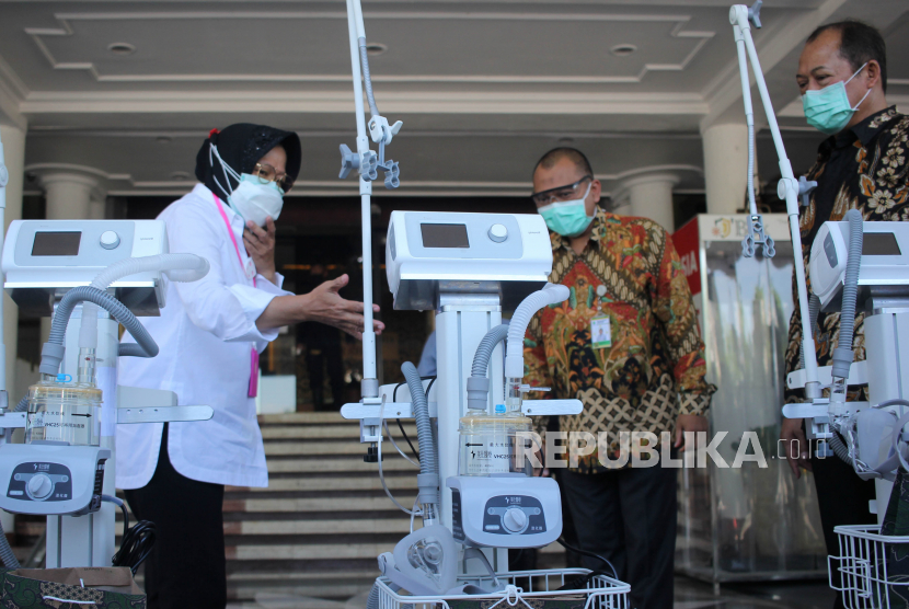 Wali Kota Surabaya Tri Rismaharini (kanan) memberikan peralatan medis kepada penerima bantuan di Balai Kota Surabaya, Jawa Timur, Selasa (30/6/2020). Pemberian bantuan berupa alat ventilator kepada sejumlah rumah sakit nonrujukan itu diharapkan dapat membantu pihak rumah sakit menangani pasien COVID19. 