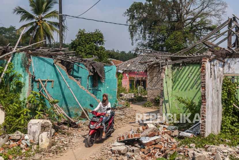 Pengendara sepeda motor melintas di antara rumah yang sudah tidak ditempati pemiliknya di Desa Bungur Mekar, Lebak, Banten, Selasa (22/8/2023). Sebanyak empat kampung yang berada di desa tersebut akan segera ditenggelamkan guna mengairi aliran air Waduk Karian pada September 2023. 