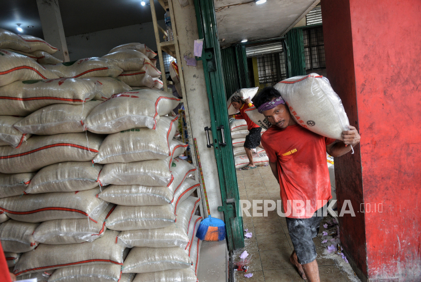 Workers transport rice at one of the wholesale grocery stores in Jakarta, Friday (23/2/2024).