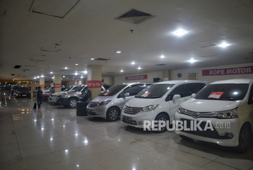 Pekerja berjalan didekat mobil bekas yang terparkir di bursa mobil bekas Mall Blok M, Jakarta, Rabu (29/5/2024). Menurut pedagang penjualan mobil bekas berbahan bakar minyak masih menjanjikan di tengah perkembangan kendaraan listrik.