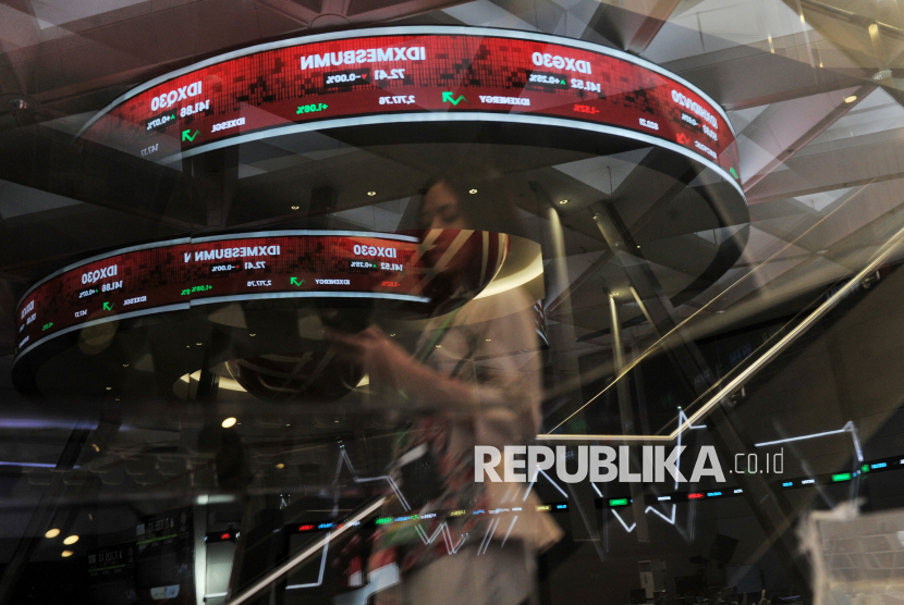 Pekerja mengamati layar yang menampilkan data pergerakan perdagangan saham.