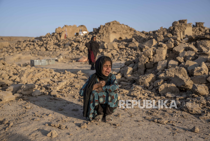 eorang gadis Afghanistan menangis di depan rumahnya yang hancur akibat gempa bumi di distrik Zenda Jan di provinsi Herat, Afghanistan barat, pada 11 Oktober 2023.