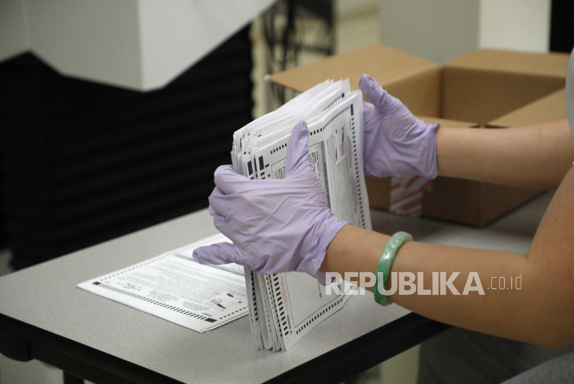  Seorang petugas pemilu mengumpulkan surat suara 