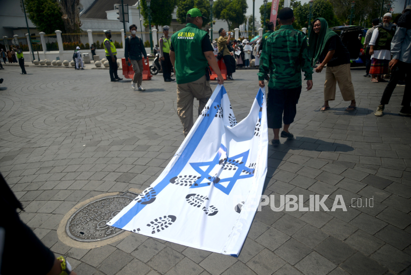 Participants from the Muslim Forum dragged Israeli flags as Indonesia intervened to help Palestinians at Zero Point Yogyakarta, Friday (13/10/2023). In a peaceful response to the Israeli-Palestinian conflict, they called on the Government to help the Palestinians by mobilising international aid. In addition, they also do fundraising to help the struggle of the Palestinian people. At the end of the action participants pray qunu nazilah in conjunction with the Ashar Prayer congregating at the scene of the action.