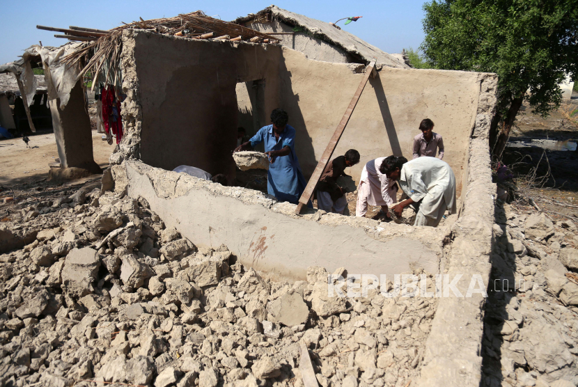  Penduduk setempat membangun kembali rumah yang rusak akibat banjir, di distrik Mirpur Khas, provinsi Sindh, Pakistan, 10 Oktober 2022. Menurut otoritas penanggulangan bencana, sekitar 160 jembatan dan 5.000 km (3.200 mil) jalan hancur atau rusak, 3,5 juta hektar tanaman terpengaruh, dan sekitar 800.000 ternak hilang. Lebih dari 33 juta orang terkena dampak banjir, kata Menteri Perubahan Iklim negara itu Sherry Rehman.