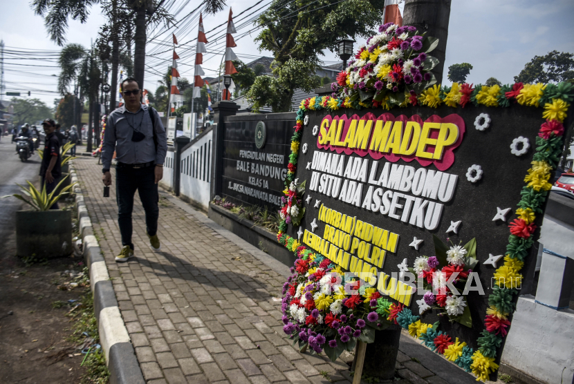 Warga melintas di dekat karangan bunga yang berisi tuntutan dan kecaman terhadap Doni Salmanan ilustrasi. Sejumlah korban dari terdakwa Doni Salmanan meluapkan amarah dengan merusak karangan papan bunga dukungan terhadap Doni di Pengadilan Negeri Bale Bandung, Kamis (15/12/2022).