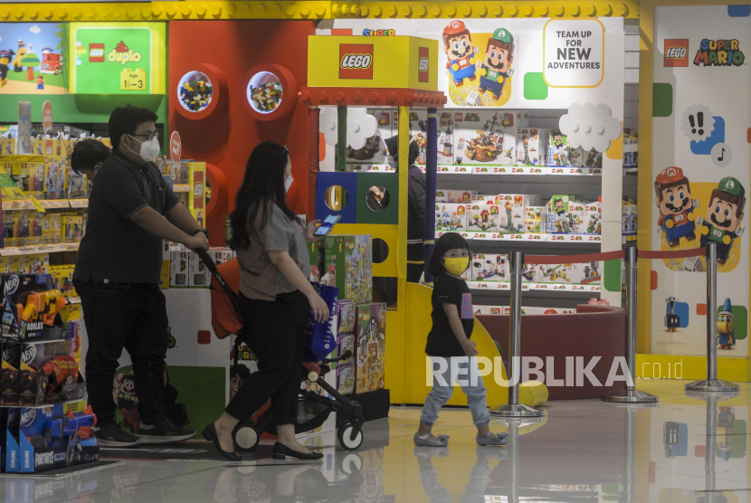 Warga bersama anaknya usai mengunjungi salah satu gerai toko di Senayan City, Jakarta. Penurunan kasus Covid-19 membuat masyarakat kembali keluar rumah dan meningkatkan mobilitasnya.
