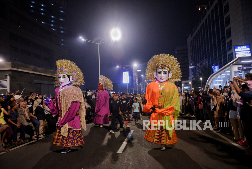 Warga menyaksikan pertunjukan karnaval saat gelaran Car Free Night di kawasan Bundaran Hotel Indonesia, Jakarta, Ahad (31/12/2023). 