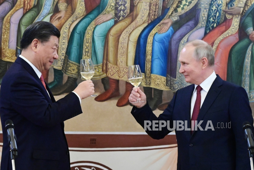 Presiden Rusia Vladimir Putin (kanan) dan Presiden China Xi Jinping bersulang saat makan malam mereka di The Palace of the Facets adalah sebuah bangunan di Kremlin Moskow, Rusia, Selasa (21/3/2023).