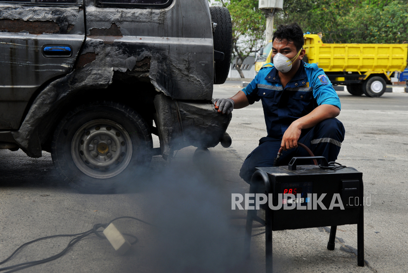 Petugas gabungan menindak pengendara pada saat razia tilang uji emisi di kawasan Cakung, Jakarta. Sebanyak 57 kendaraan terjaring tilang uji emisi di hari pertama razia di Jakarta.