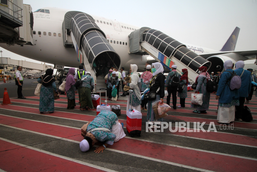 Jamaah haji melakukan sujud syukur saat tiba di Bandara Internasional Juanda Surabaya di Sidoarjo, Jawa Timur, Selasa (4/7/2023). Sebanyak 450 jamaah haji kloter pertama asal Bangkalan, Madura kembali ke tanah air setelah menunaikan ibadah haji.  