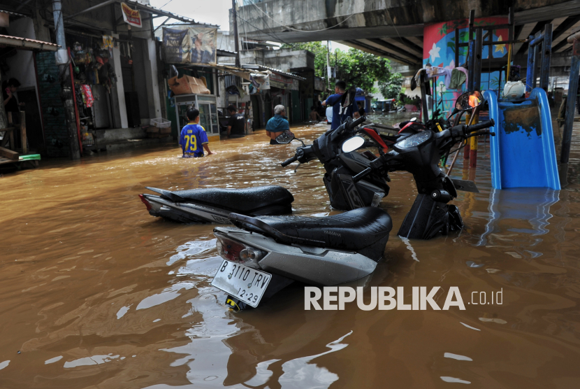 Warga beraktivitas saat banjir di Rawajati, Jakarta, Selasa (4/3/2025). Berdasarkan data BPBD DKI Jakarta mencatat, sebanyak 59 RT di kawasan Rawajati dan Cililitan terendam banjir dengan ketinggian mulai dari 30-300 centimeter yang disebabkan oleh meluapnya kali Ciliwung.