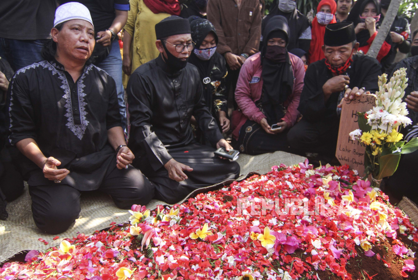 Adik almarhum Omaswati, Mastur (kiri) bersama keluarga membacakan doa saat pemakaman di Cimanggis, Depok, Jawa Barat, Jumat (17/7/2020). Seniman betawi Omaswati atau Omas meninggal dunia pada usia 54 tahun pada Kamis (16/7/2020) sekitar pukul 19.30 WIB karena sakit. 