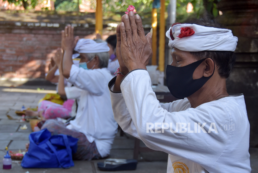Umat Hindu melakukan persembahyangan Hari Tumpek Wayang dengan mengikuti protokol kesehatan di Pura Dalem Kahyangan Badung, Denpasar, Bali, Sabtu (13/6). (ilustrasi)