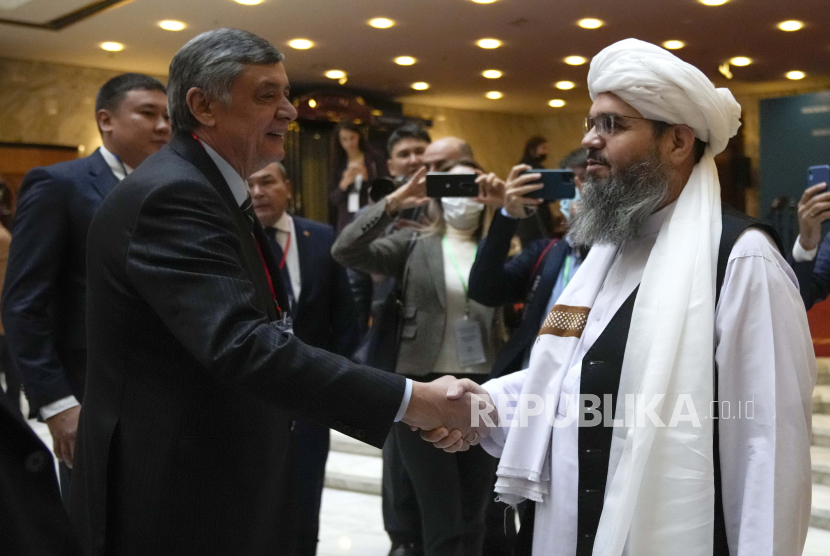  Utusan presiden Rusia untuk Afghanistan Zamir Kabulov (kiri) berjabat tangan dengan anggota delegasi politik dari gerakan Taliban Afghanistan Mawlawi Shahabuddin Dilawar (kanan) sebelum pembukaan pembicaraan yang melibatkan perwakilan Afghanistan di Moskow, Rusia, 20 Oktober 2021. 