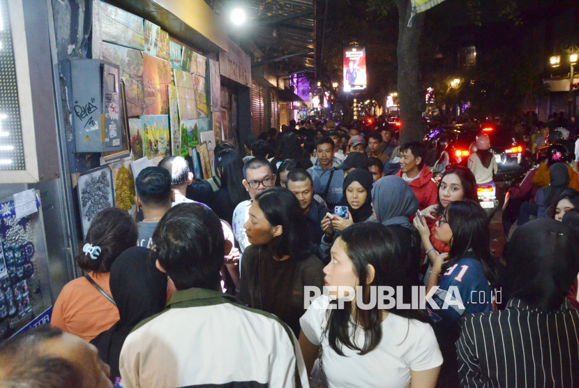 Kepadatan pengunjung saat malam tahun baru 2025 di Jalan Braga Kota Bandung, Selasa (31/12/2024). Selain kawasan Baraga, keramaian warga di malam pergantian tahun tumpah di sejumlah titik di pusat Kota Bandung, seperti di kawasan Alun-alun, dan Jalan Asia Afrika.