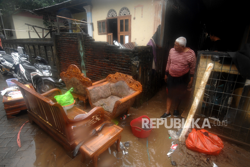 Warga membersihkan rumahnya dari endapan lumpur pascabanjir di Kelurahan Ternate Tanjung, Manado, Sulawesi Utara, Ahad (17/1/2021). Hujan berintensitas tinggi selama dua hari mengakibatkan banjir dengan ketinggian air mencapai satu hingga satu setengah meter di sejumlah lokasi di Manado. 