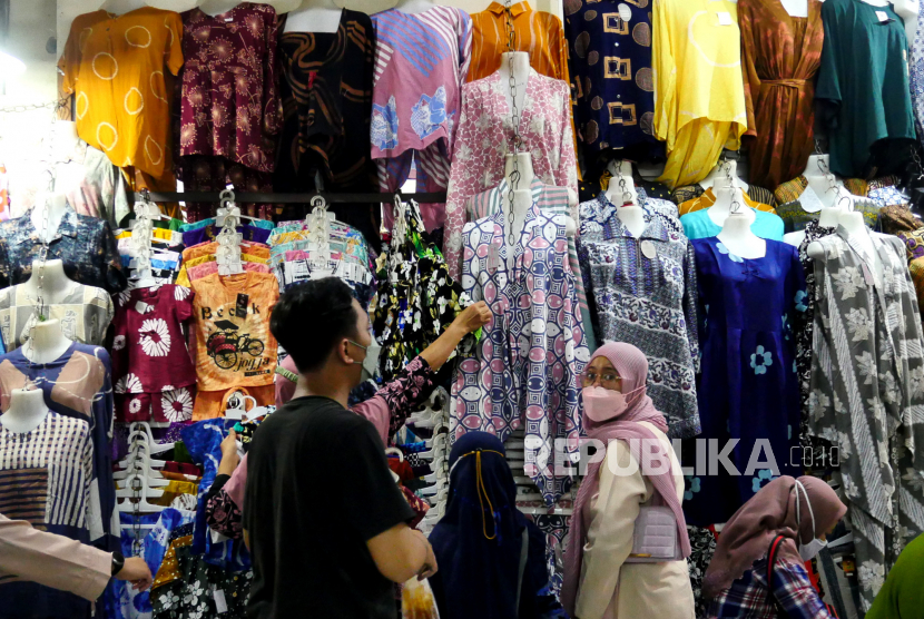 Pembeli memilih pakaian di Pasar Beringharjo, Yogyakarta, Ahad (3/10). Geliat jual beli di los pakaian Pasar Beringharjo mulai terlihat pada pekan ini. Perlahan pengunjung pasar mulai kembali sejak status Yogyakarta turun menjadi PPKM Level 3 dan dibukanya sektor pariwisata.