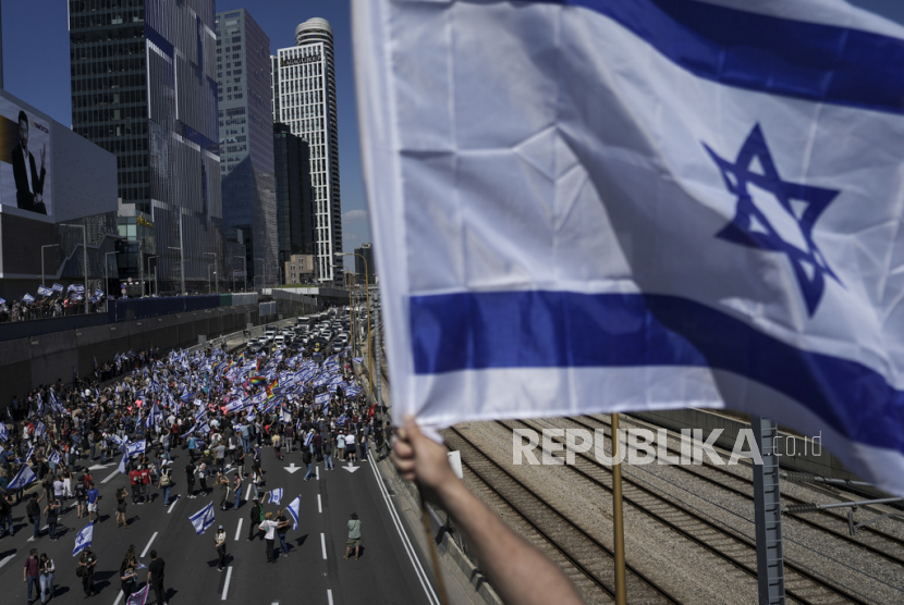 Warga Israel memprotes rencana pemerintah baru Perdana Menteri Benjamin Netanyahu untuk merombak sistem peradilan memblokir jalan bebas hambatan utama di Tel Aviv, Israel, Kamis (16/3/2023).