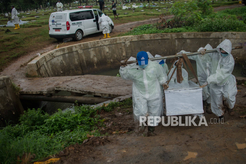 Petugas menggunakan pakaian alat pelindung diri (APD) saat memakamkan jenazah pasien Covid-19 di TPU Srengseng Sawah, Jagakarsa, Jakarta, Kamis (21/1). Keterisian makam di TPU Srengseng Sawah mencapai 95 persen dengan total sebanyak 498 jenazah telah di makamkan dan tersisa 62 petak, sejak dijadikan tempat pemakaman khusus pasien Covid-19 pada Selasa (12/1) lalu. Republika/Thoudy Badai