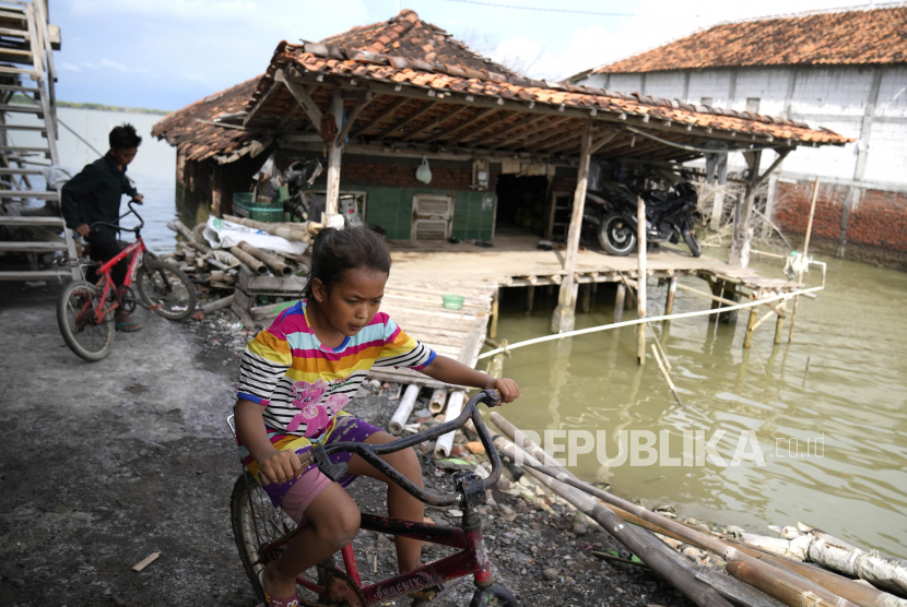  Anak-anak bermain di dekat rumah yang terendam air laut akibat naiknya permukaan air laut di desa Bedono, Jawa Tengah, Senin (8/11/2021). Ilmuwan melakukan analisis kapan pertama kalinya terjadi kenaikan air laut yang tajam.