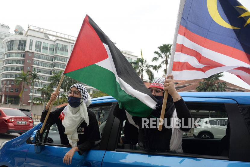 Pengunjuk rasa membawa bendera Malaysia dan Palestina (ilustrasi). 